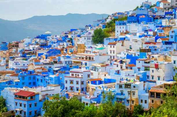 Panoramic view of Chefchaouen in northern Morocco, showing the blue-painted medina surrounded by the Rif Mountains.