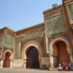 Bab Mansour gate in Meknes, Morocco, featuring monumental Moroccan Islamic architecture and intricate zellige tilework.